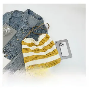 Macro detail of yellow and white knit tote bag with premium brown leather shoulder straps
