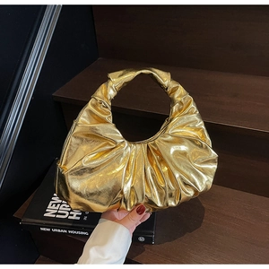 Detailed view of metallic gold ruched hobo bag featuring pleated crescent moon design