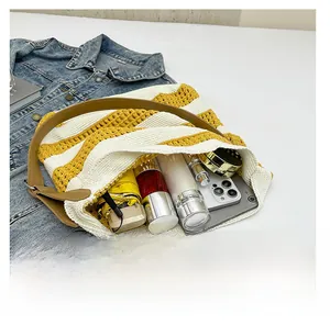 Close-up of yellow striped knit tote showing large capacity with umbrella and phone