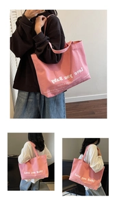 Close-up detail of pink canvas tote bag featuring Love you Baby artistic letter printing