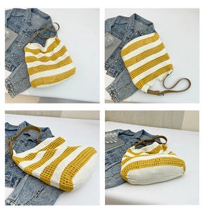 Detail view of woven knit tote bag featuring yellow stripes and brown leather strap