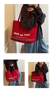 Detail of red canvas tote bag showing durable texture and Love You Baby print