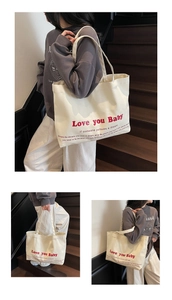 Detail of canvas tote bag showing red Love you Baby print and thick shoulder straps