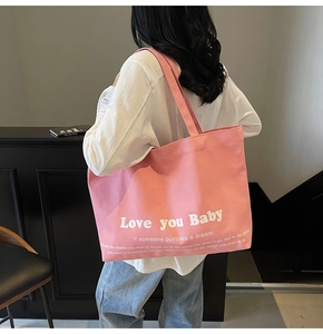 Detailed back view of a large pink canvas tote bag showing its size and fit on a model