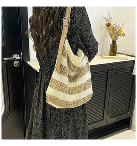 Close-up of striped knit tote bag with adjustable leather strap and textured weave