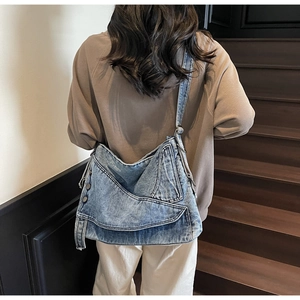 Detailed back view of a denim patchwork tote bag with visible metal rivets and stitching