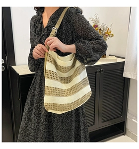 Detail of crochet knit striped tote showing texture and adjustable leather strap