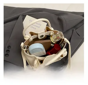 Macro view showing the internal capacity of the beige litchi grain leather bucket bag