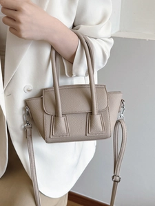 Elegant beige pebbled leather bucket bag with top handles and adjustable strap for women
