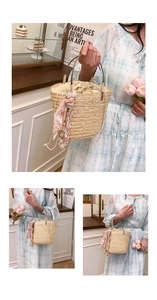 Detail of hand-woven straw bucket bag with floral scarf and pearl charm accessory