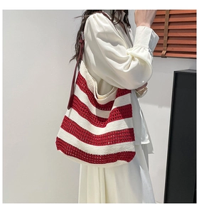 Close-up of red and white striped knit tote bag with deep red leather shoulder straps