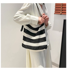Close-up of black and white striped knitted tote bag with woven hollow texture