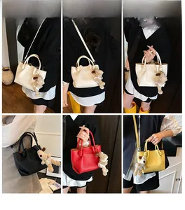 Litchi pattern bucket bag in four colors shown with a cute dog plush charm accessory