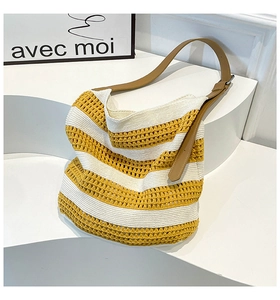 Detail of yellow knit tote with hollow texture and adjustable brown leather strap