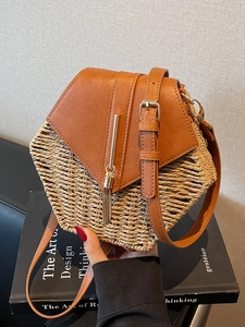 Vintage straw woven bucket bag with brown leather trim and golden tassel detail