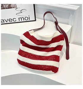 Detail of red and white striped knit tote bag with adjustable leather shoulder strap