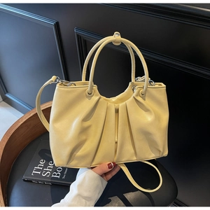 Detail of beige pleated handbag in oil wax leather finish with handle and crossbody strap