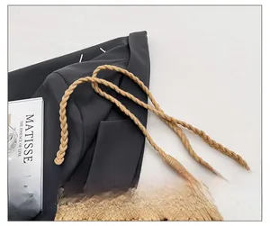 Détail du sac seau tissé à la main avec bandoulière tressée et boucle métallique