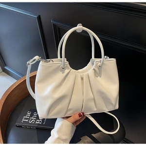 Detail of white pleated cloud bag with elegant leather texture and silver hardware