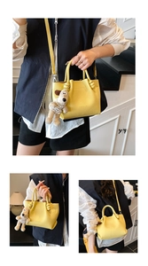 Detail of lychee pattern leather bucket bag with knotted handle and puppy charm