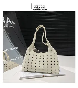 Close-up of white tote bag with silver metal eyelet studs and premium lychee grain texture