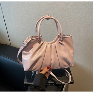 Detailed macro view of handmade ruched leather texture on the dusty pink crossbody handbag