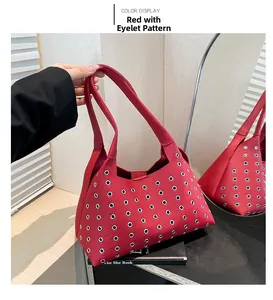 Detailed macro view of red leather shoulder bag with silver metal eyelet grommets