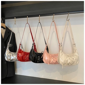 Detailansicht von fünf glänzenden Halbmond-Schultertaschen mit Schleifen-Details
