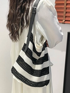 Large black and white striped crochet woven tote bag with a black leather shoulder strap