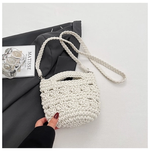 Détail d'un sac seau blanc tissé à la main avec motif en résille et bandoulière en corde