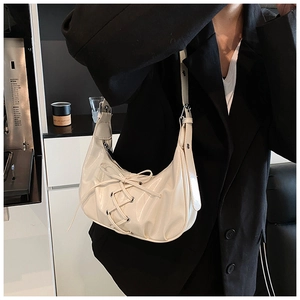 Nahaufnahme der cremeweißen Lackleder-Schultertasche mit stilvollem Schleifendesign