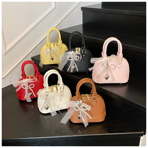 Mini shell-shaped handbags in six colors with lace bows and pearl charms on stairs