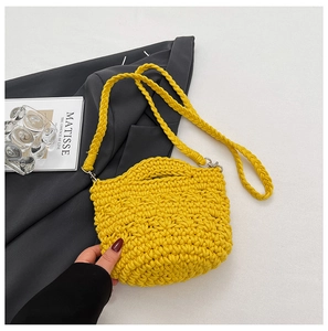 Détail d'un sac seau au crochet jaune vif avec texture ondulée texture et bandoulière tissée