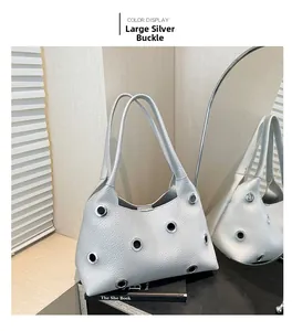 Detailed close-up of silver grommet studs on metallic faux leather shoulder bag