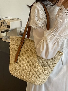 Beige straw tote bag with brown leather straps for summer beach or casual commuting use