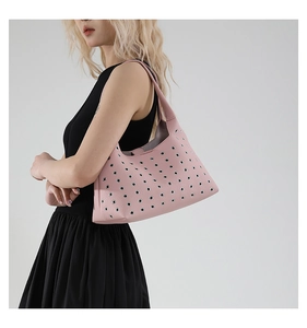 Detailed view of pink textured leather shoulder bag featuring decorative silver rivets