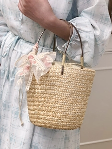 Handwoven straw bucket bag with floral lace ribbon and drawstring liner for beach vacations