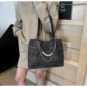 Detail der glitzergrauen Shopper Tasche mit Perlenbesatz und doppelten Metallketten