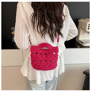 Détail du sac seau au crochet fuchsia avec texture tissée et boucle en métal argenté