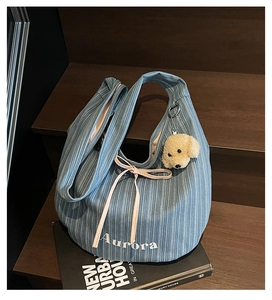Blue corduroy Aurora tote bag detail with pink ribbon and cute puppy plush pendant