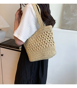 Détail d'un sac cabas en paille fait main avec motif floral au crochet ajouré
