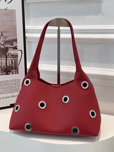 Minimalist red leather handbag with silver stud rivets and a modern integrated handle