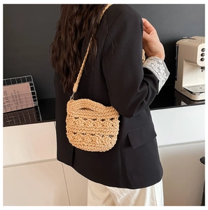 Gros plan d'un sac seau beige tressé à la main avec motif au crochet sur un mannequin