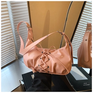 Detailansicht der rosa Lackledertasche mit dekorativem Schnürband-Design und Glanz-Finish