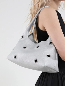Fashionable silver leather handbag with large metal eyelet studs and grainy texture for women
