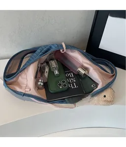 Top view of striped denim tote bag showing spacious interior with pink lining and essentials