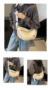 Detail view of off-white crescent crossbody bag with adjustable wide strap and buckle