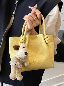 Chic bright yellow lychee texture bucket bag with knot handle and dog charm accessory