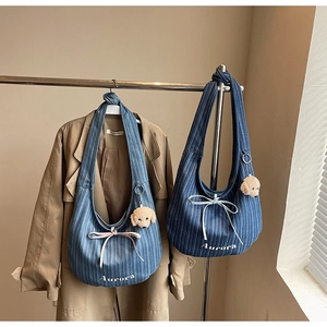 Detail of vintage striped denim hobo bags with bow ribbons and plush puppy charms