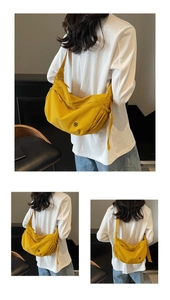 Macro detail of vibrant yellow crossbody hobo bag with wide strap and logo hardware